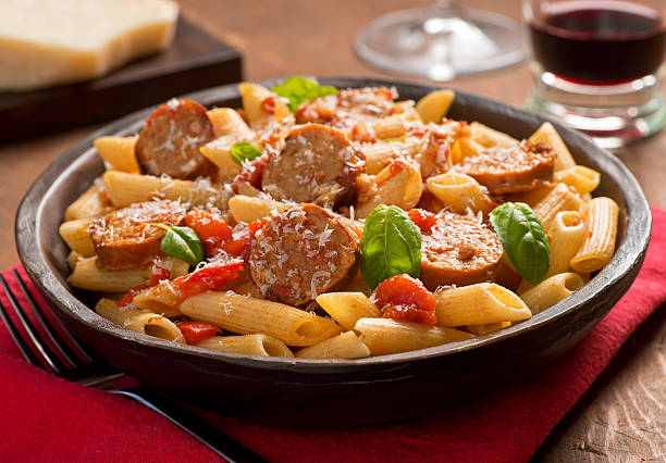 Pasta with Sausage Cajun style pasta with penne, spicy sausage, red peppers, and tomato sauce with freshly grated parmesan cheese. cajun food photos stock pictures, royalty-free photos & images
