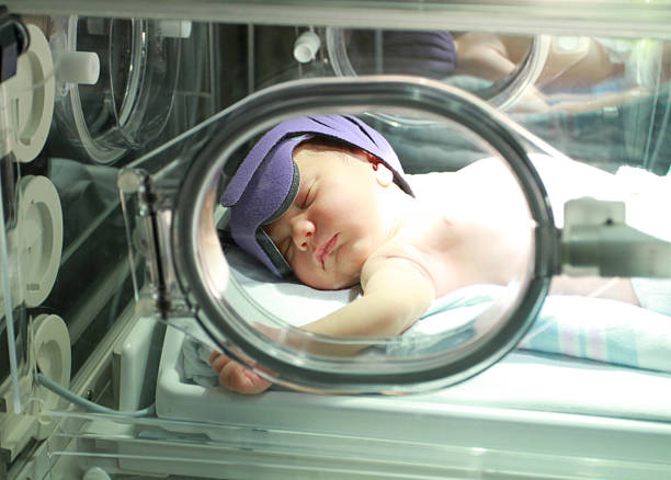 jaundiced ребенка в больнице в свет - yellowing стоковые фото и изображения