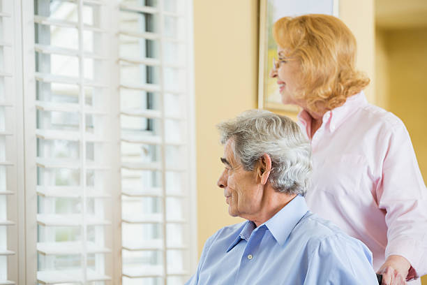 istock Senior couple looking out window at home 461222673