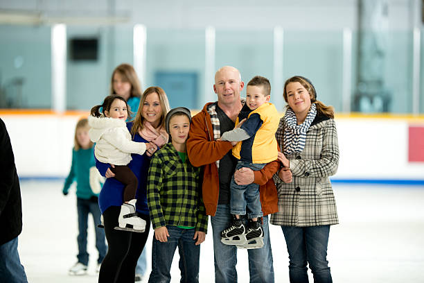 famille debout sur une patinoire - ice skating young couple daughter mother photos et images de collection