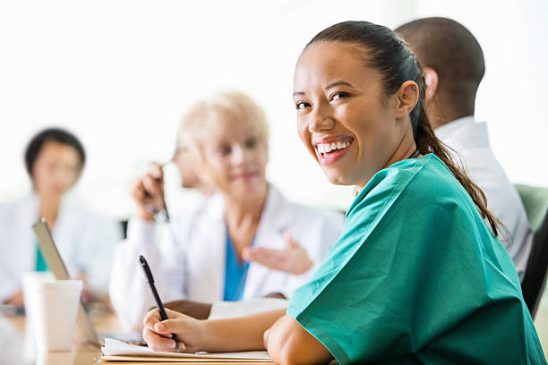 istock Friendly hospital doctor or intern writing in chart during meeting 461225943