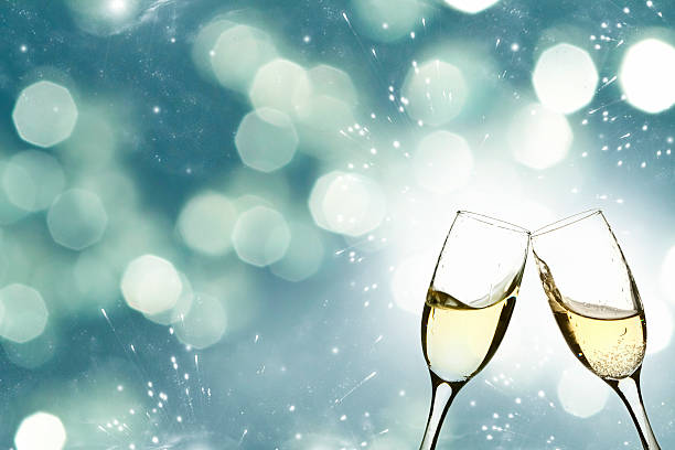 Glasses with champagne against holiday lights stock photo