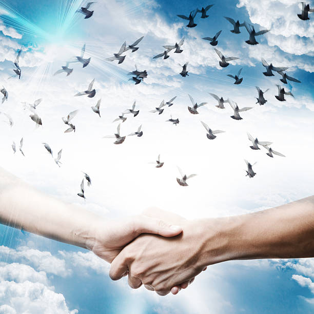 istock hand shake with dove flying on sky 461233905