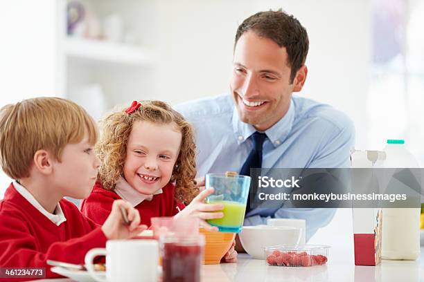 Father And Children Having Breakfast In Kitchen Together Stock Photo - Download Image Now