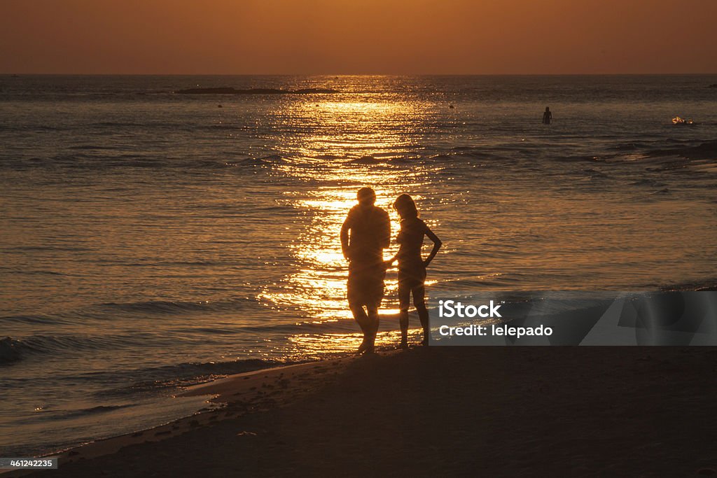 Couple marchant sur le littoral silouette au coucher du soleil - Photo de Marcher libre de droits