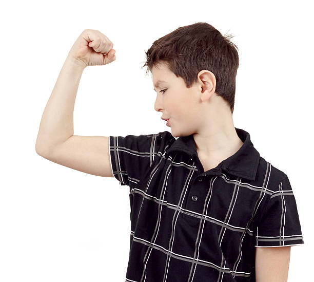 istock young boy with hand raised up and showing muscles 461242491