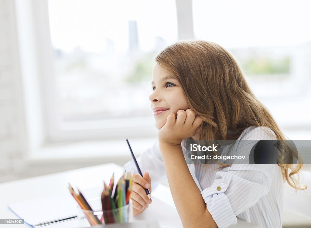 little student girl drawing and dreaming at school education, creation and people concept - smiling little student girl drawing and daydreaming at school Baby Girls Stock Photo