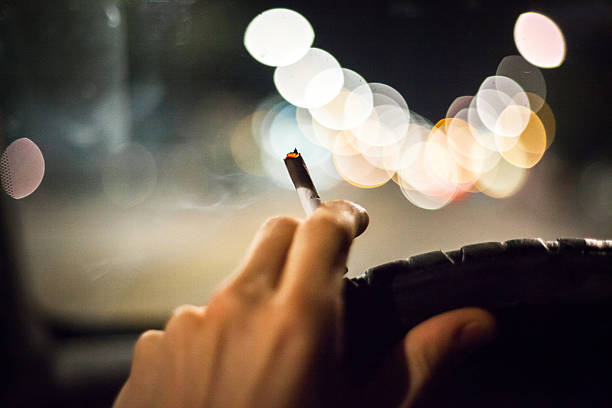 Man with cigarette in car stock photo