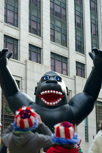Philadelphia, PA, United States, January 1, 2014: Onlookers see how an inflatable gorilla glides between the buildings in center city Philadelphia. The inflatable balloon is part of the annual Mummers Parade that takes place on the first day of the year.