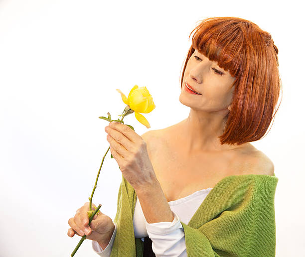 istock Senior Female Admiring A Rose 461261283