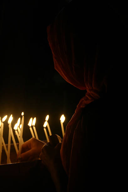 istock LIGHTING A CANDLE IN CHURCH 461262519