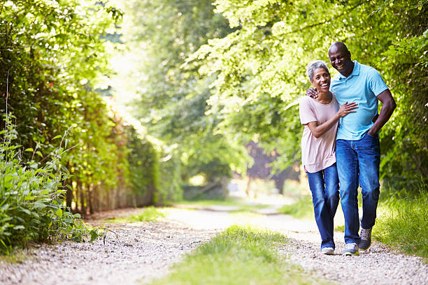 Elderly couple walking along a gravel path with trees
