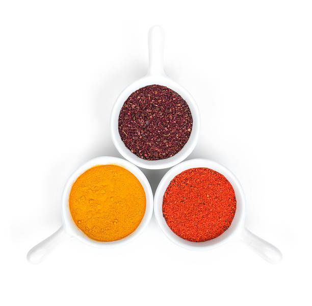 Three spices in white measuring cups on a white background
