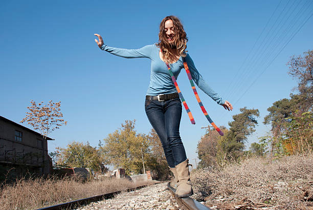 istock Young woman walking on a railroad track 461282525