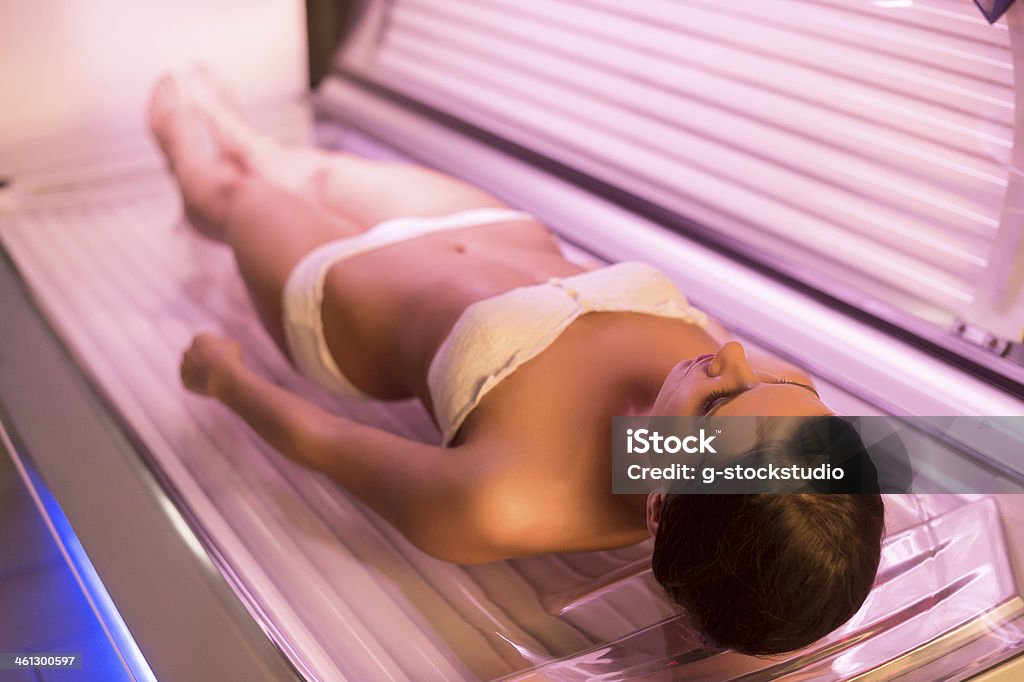 Mujer en la cama solar. - Foto de stock de Acostado de espalda libre de derechos