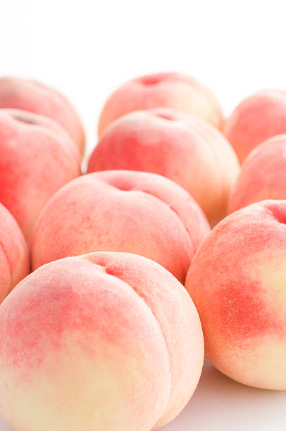 A pile of orange peaches on a white background