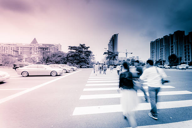 Motion blurred people walking on crosswalk.