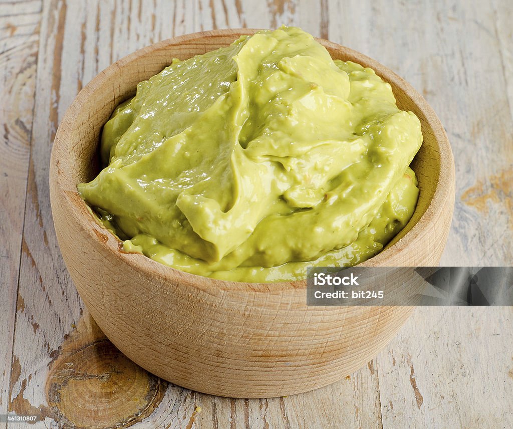 guacamole Bowl with guacamole on wooden table. Selective focusGuacamole on wooden table Appetizer Stock Photo