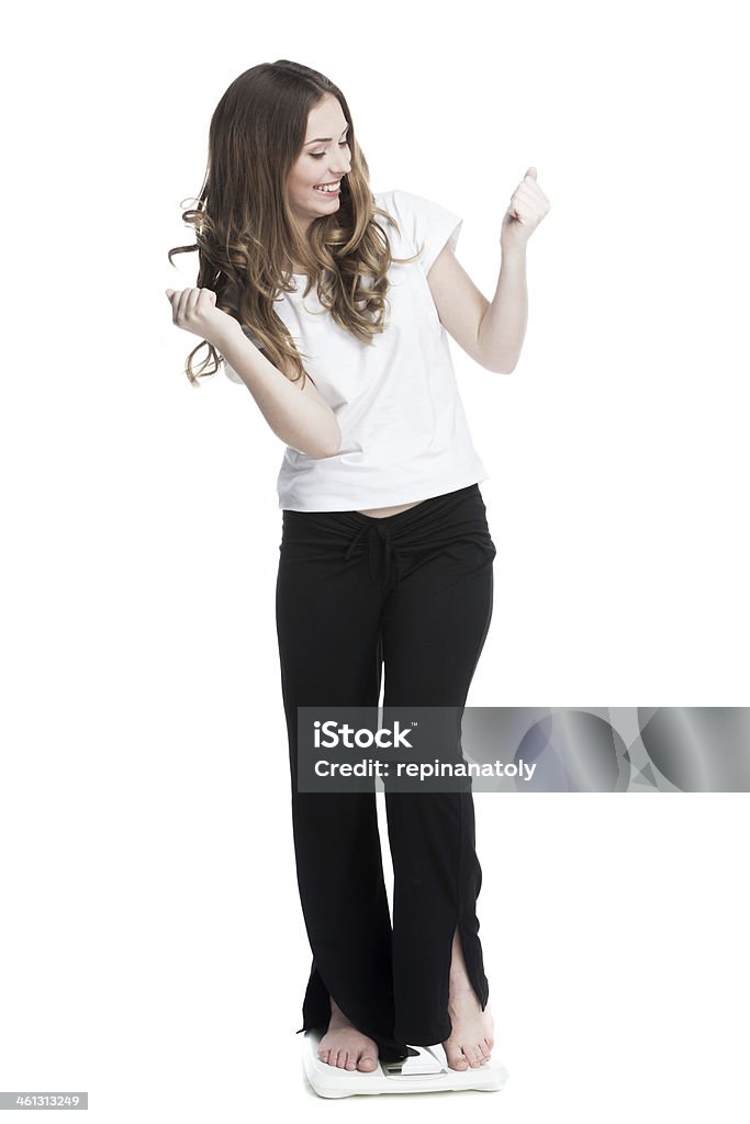 young beautiful brunette girl standing on the scales measuring weight 20-29 Years Stock Photo