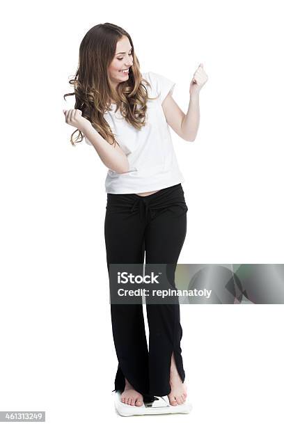 Young Beautiful Brunette Girl Standing On The Scales Measuring Weight Stock Photo - Download Image Now