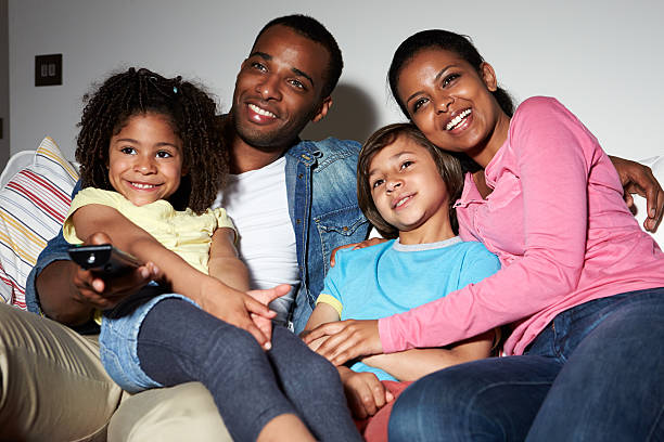 istock Family Sitting On Sofa Watching TV Together 461313729