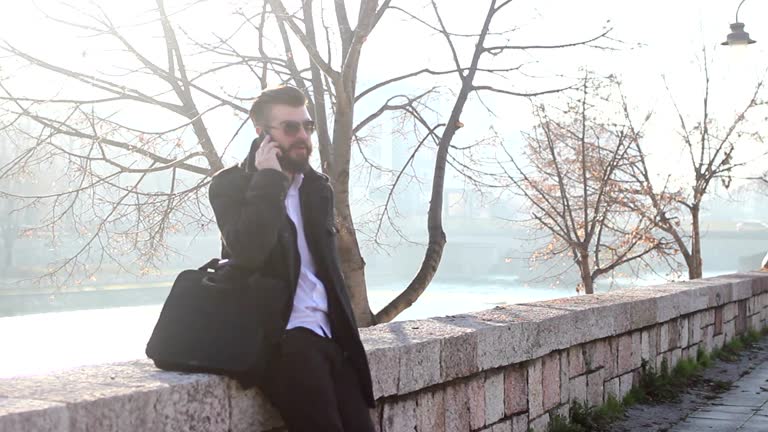 Handsome businessman talking on  phone outdoors