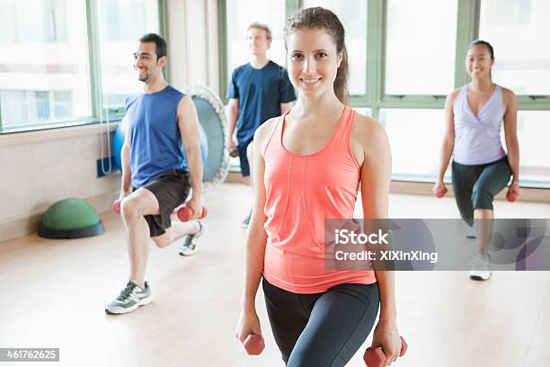 Four People Stretching In Aerobics Class Stock Photo - Download Image Now - Exercise Class, Indoors, Dumbbell