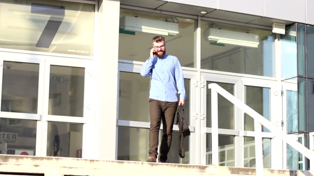 Young businessman leaving work and talking on the phone