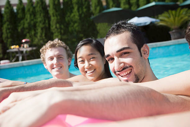 istock Four friends in the pool with an inflatable raft 461772129
