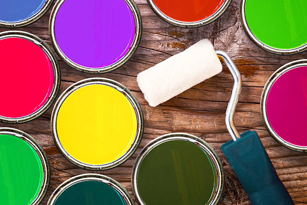 istock Paint roller and color tin cans on wooden background 461772267