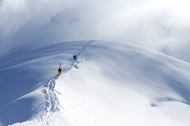 istock Skiers climbing a snowy mountain 461783003