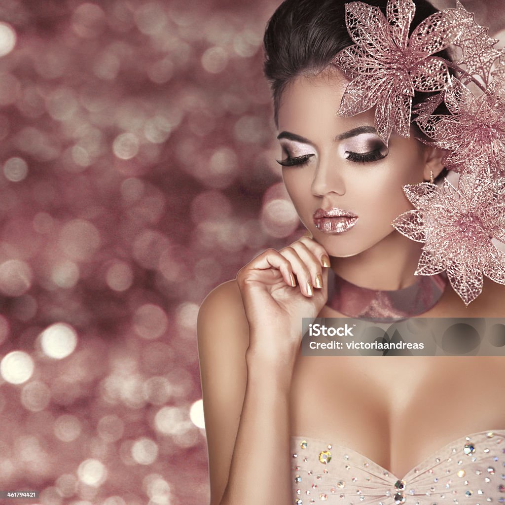 Beautiful Girl With Pink Flowers. Beauty Model Woman Face. Beautiful Girl With Pink Flowers. Beauty Model Woman Face. Isolated on bokeh lights Background.  Perfect Skin. Professional Make-up. Makeup. Fashion Art. Pink Color Stock Photo