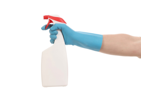 Hand in gloves holds spray bottle. Isolated on a white background.