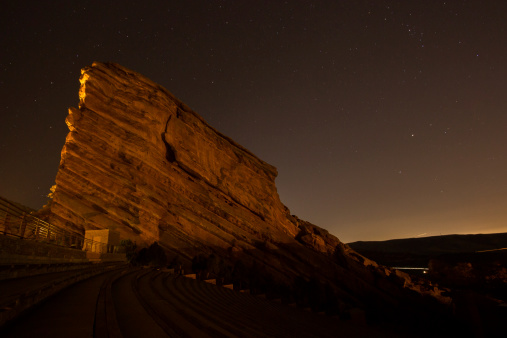 Red rock at Red Rock Amphitheatre near Denver, Colorado at night. Stars are visible as is a shooting star in the bottom right corner.