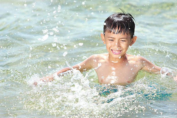 Kid swimming and splashing in the beach