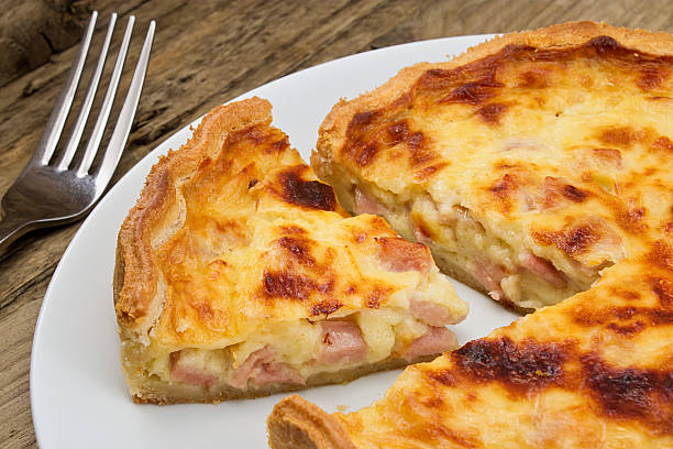 Quiche lorraine slice Portion of cheese and bacon flan cut from the quiche lorraine in a rustic traditional farmhouse setting quiche stock pictures, royalty-free photos & images