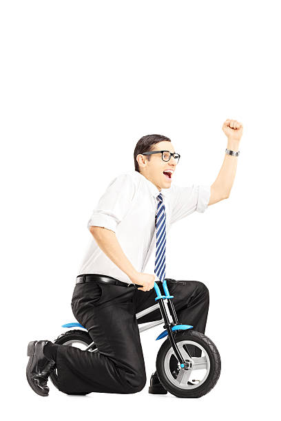 istock Excited young businessperson riding a small bicycle and gesturing 461807959