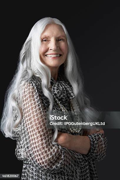 Senior Woman Crossing Arms And Smiling Stock Photo - Download Image Now - Curly Hair, Gray Hair, Long Hair