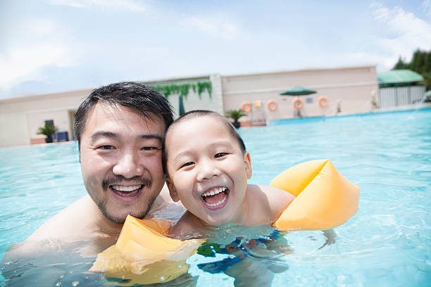 istock Smiling father and son in the pool on vacation 461846641