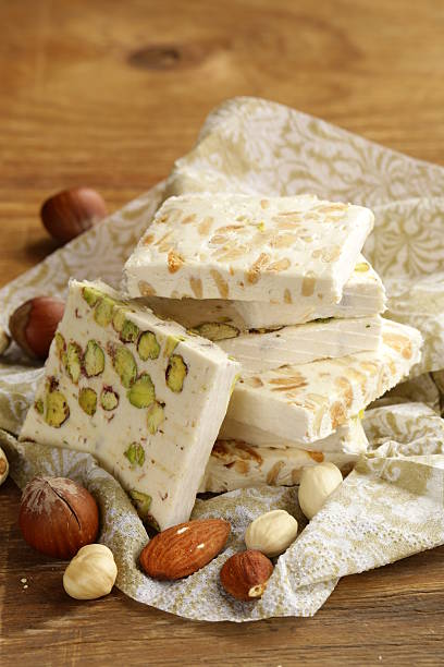 istock white nougat with different nuts on a wooden table 461850619