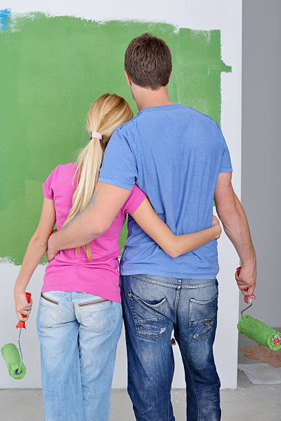 istock happy couple paint wall at new home 461853337