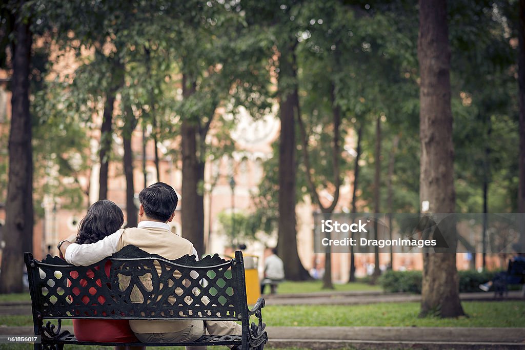 Pastime outdoors Rear view of a senior couple sitting on the bench in the park Adult Stock Photo
