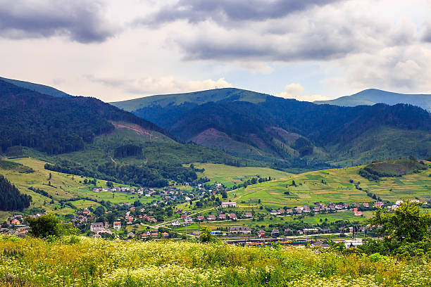 istock light  beam falls on hillside with autumn village in mountain 461856429