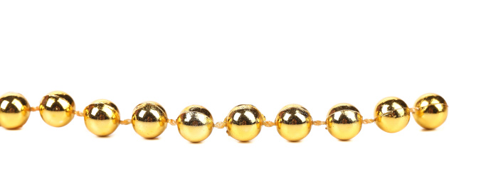 Decorative golden beads. Horisontal. Isolated on a white background.