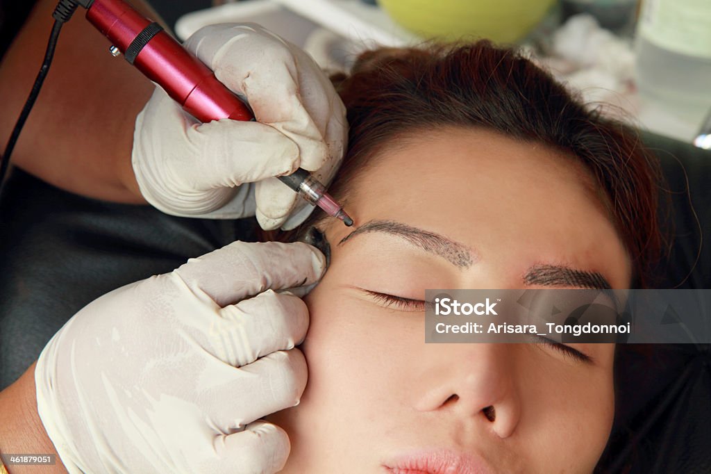 Cosmetologist making permanent makeup on face woman's . Permanent Make-Up Stock Photo