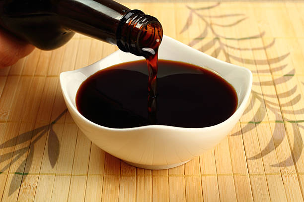 Pouring soy sauce into a white bowl Pouring Soy Sauce into bowl soy sauce photos stock pictures, royalty-free photos & images