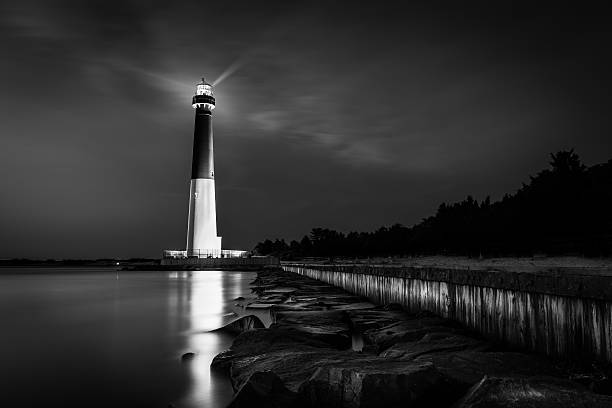 Vision is seeing the invisible Barnegat lighthouse by night in Barnegat Light, NJ. lighthouse lighting equipment reflection rock stock pictures, royalty-free photos & images