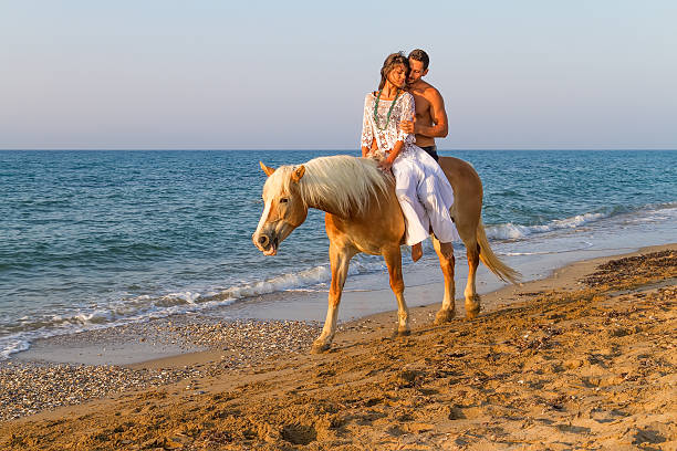 istock Attractive couple with a  horse on the beach 461887191