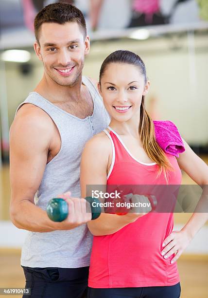 Happy Couple Working Out With Dumbbells In Gym Stock Photo - Download Image Now - Active Lifestyle, Adults Only, Beautiful People