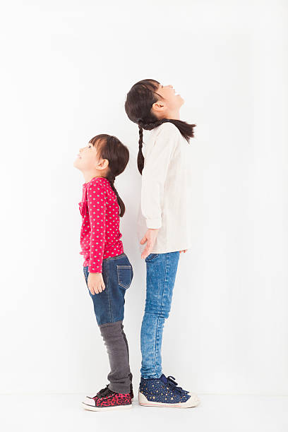 istock two little girls standing together and looking up 461910529